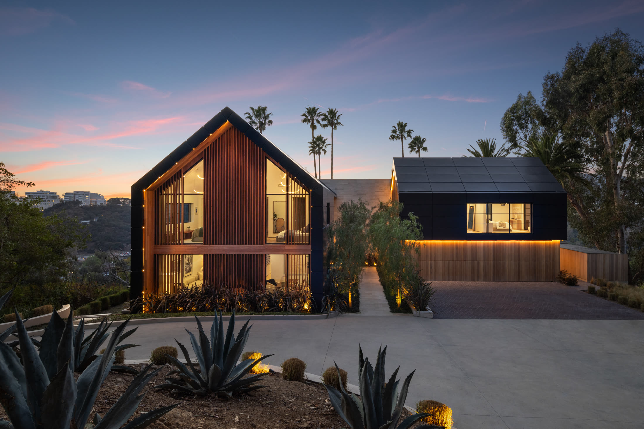 879 Linda Flora at dusk, a modern gabled estate in Bel Air framed by palms